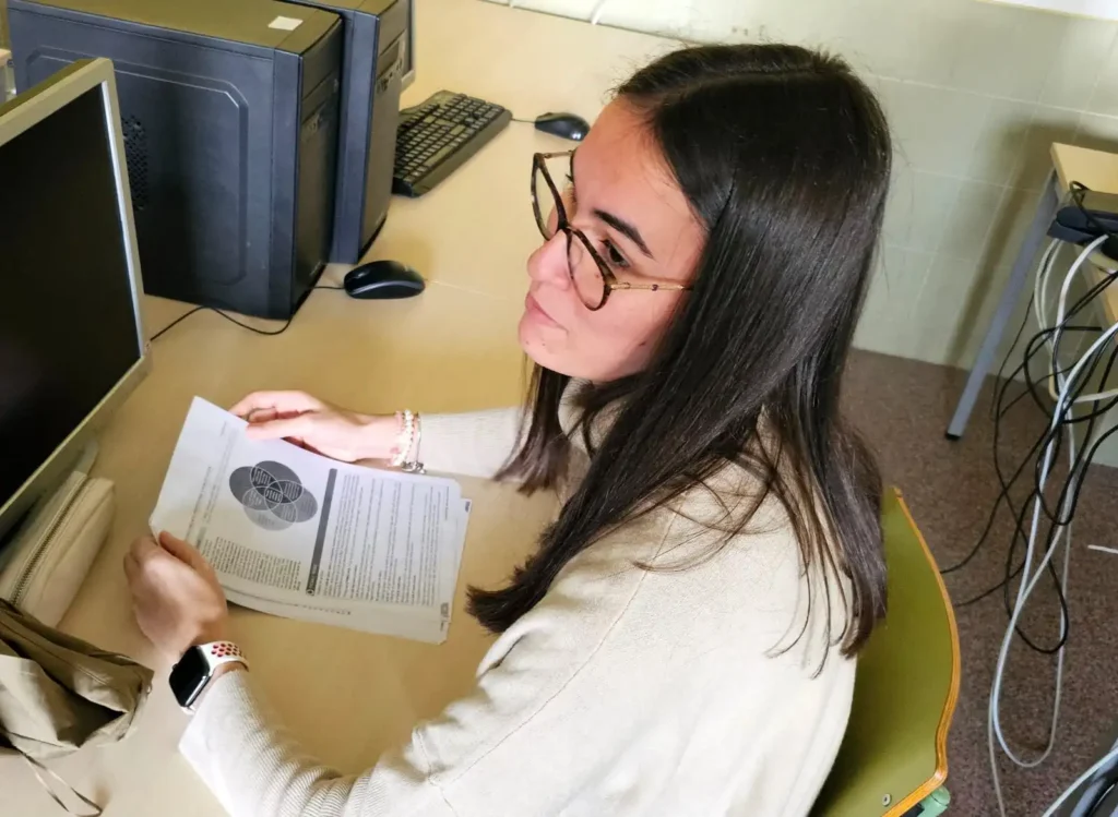 Ainhoa Torres en frente de un ordenador analizando documentación en papel