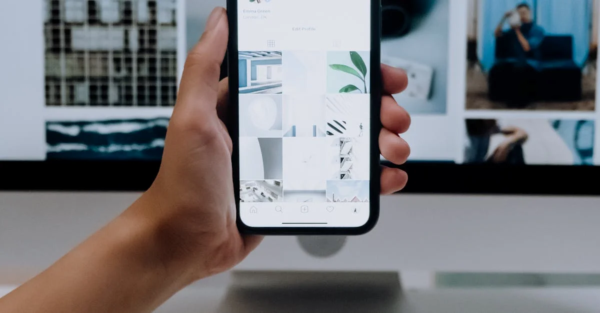 Qué es el diseño mobile-first: diseño enfocado en móviles. Una persona usa un teléfono inteligente frente a una pantalla de computadora que muestra fotografías de archivo y muestra el uso de tecnología moderna.
