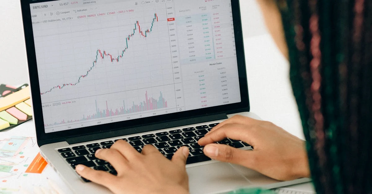Una mujer trabajando en un análisis financiero usando una computadora portátil con un gráfico del mercado de valores en la pantalla.
