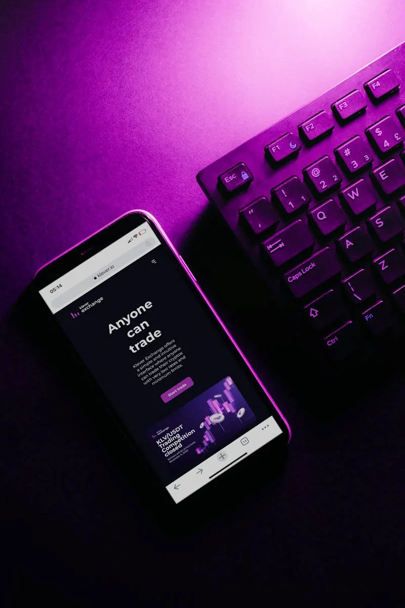 smartphone con teclado de pc al lado sobre una mesa moderna de color morado