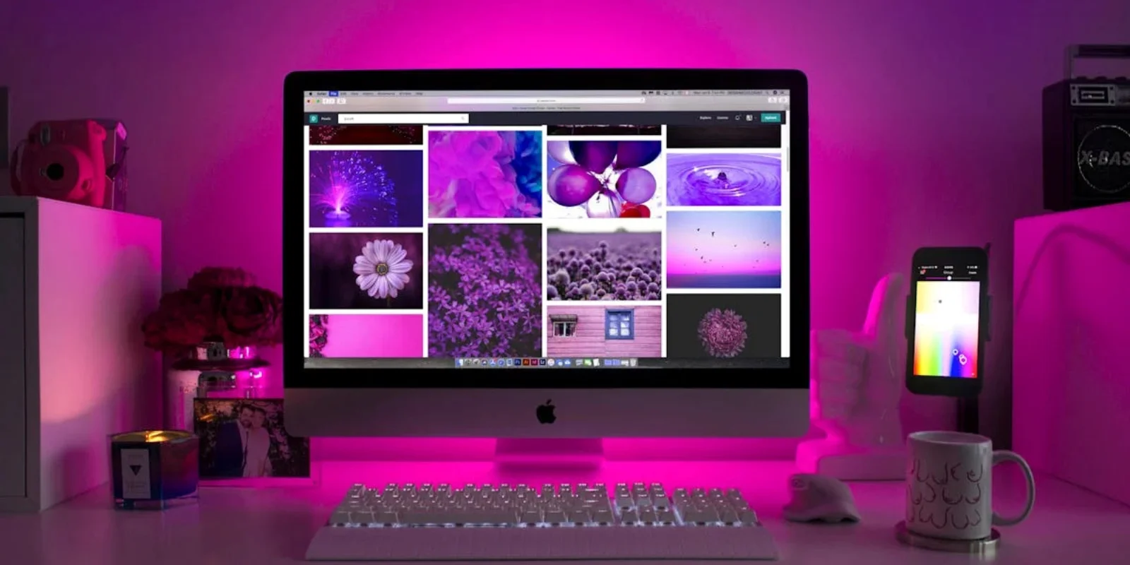 Escritorio moderno con iluminación de neón y una computadora de escritorio que muestra imágenes coloridas.